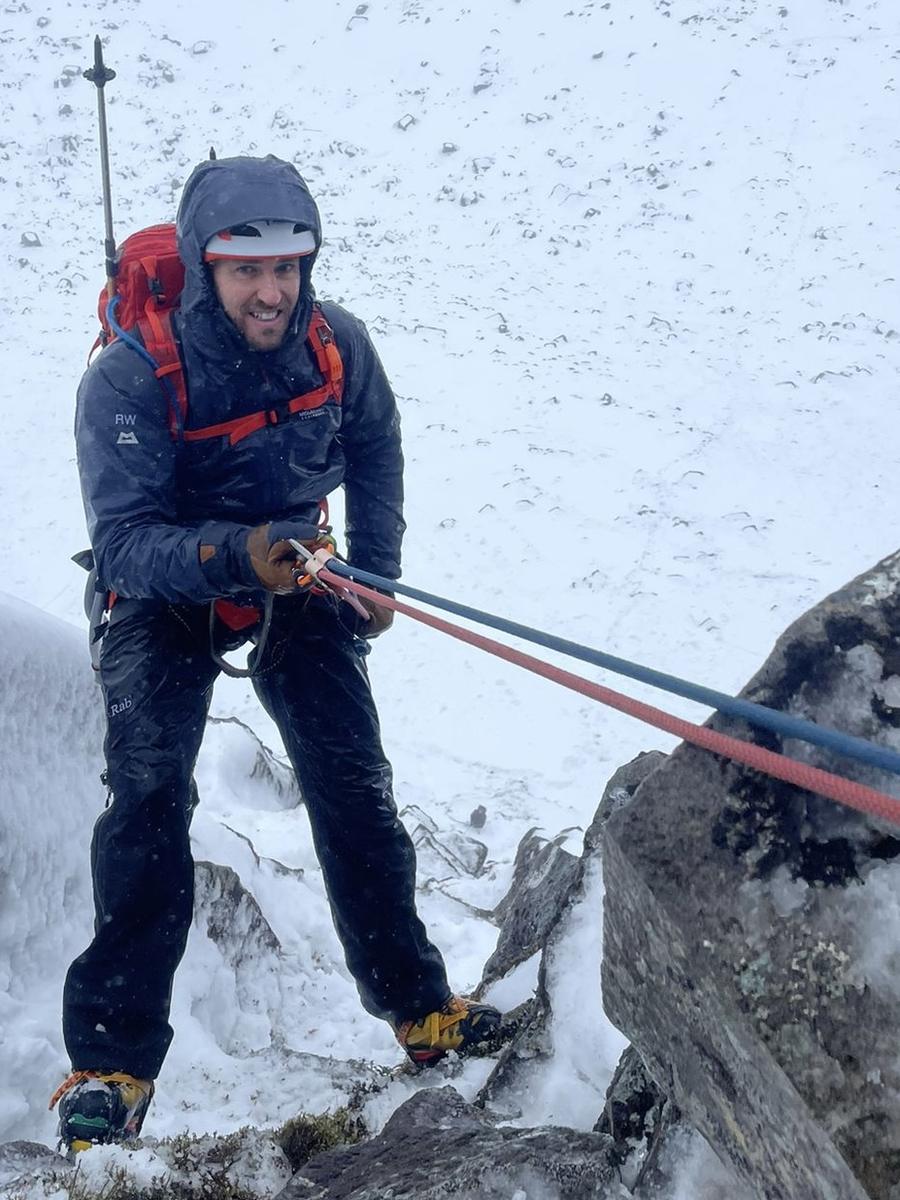 Rob Wilkinson abseiling down a snow-covered rock face