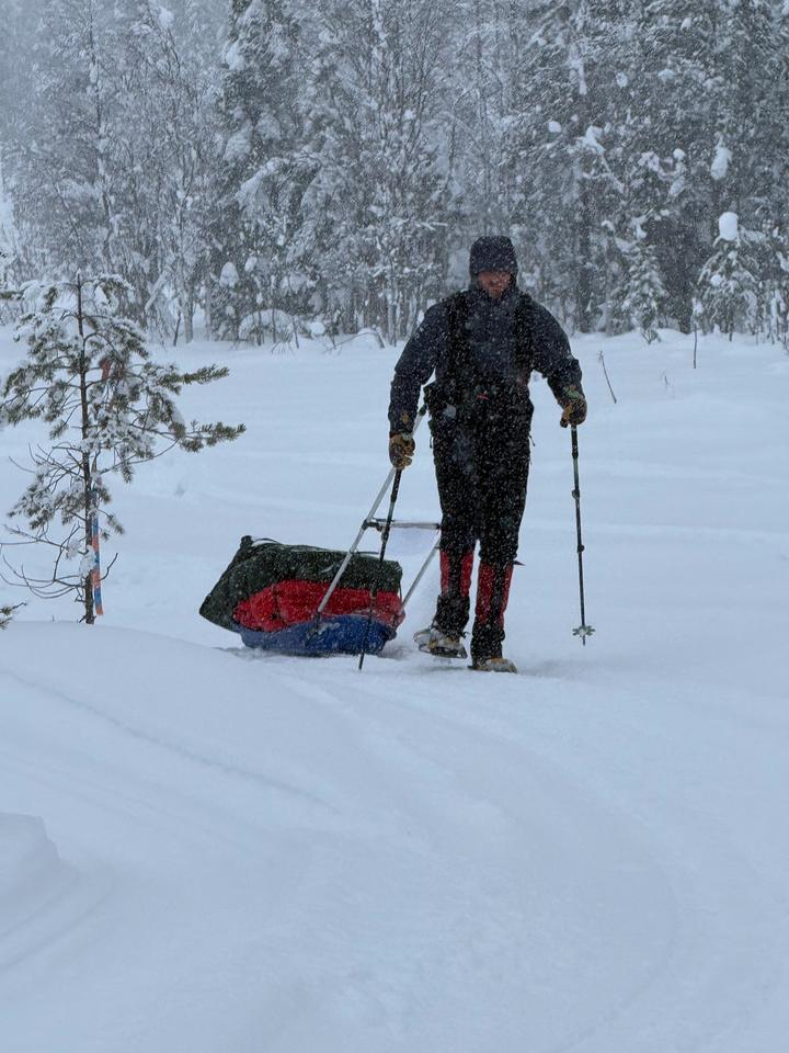 Rob Wilkinson hauling a pulk through falling snow